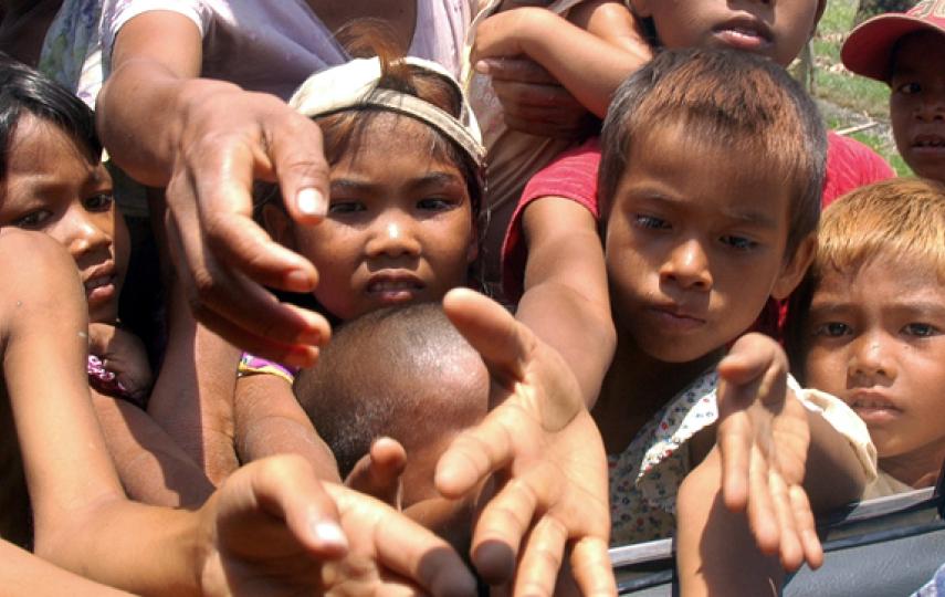 Survivors of Cyclone Nargis reach out to receive food aid in the outskirts of Myanmar's largest city Yangon on May 12, 2008. The United Nations said on May 12 it was still awaiting two-dozen visas for its foreign staff to enter Myanmar, and that the regim