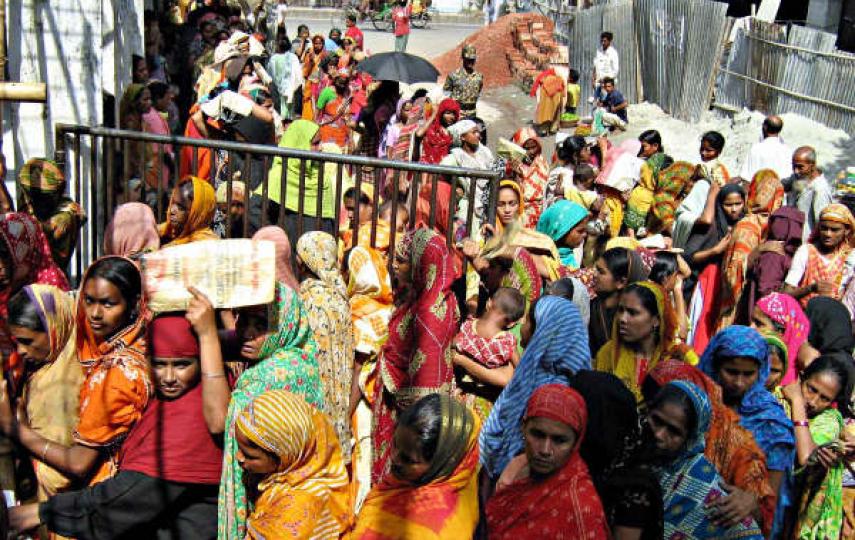 Each year river erosion lleaves thousands of people homeless. These people then throng the cities in search of jobs. Photo shows women waiting for cheap rice sold by the the government. Most of these people are climate change refugees from the southern di