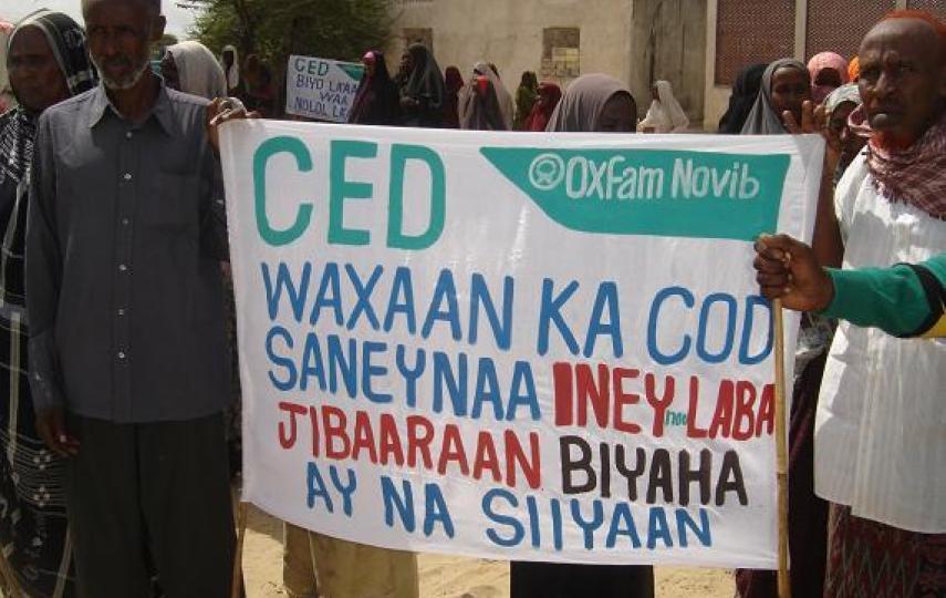 Somali IDPs hold up a banner during a demonstration in the Afgoye Corridor over claims that two NGOs were to discontinue water provision to the IDP camps