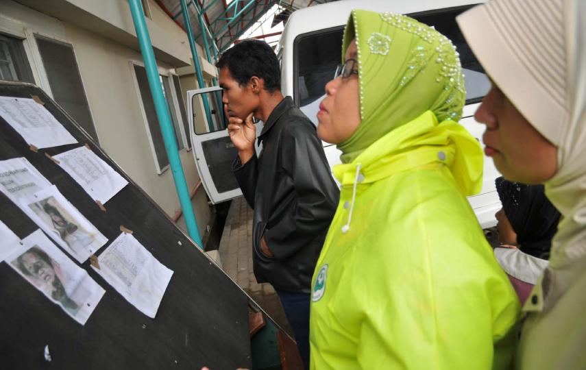 Quake survivors look for missing people on an announcement board at Mohammad Jamil Hospital in Padang, West Sumatra
