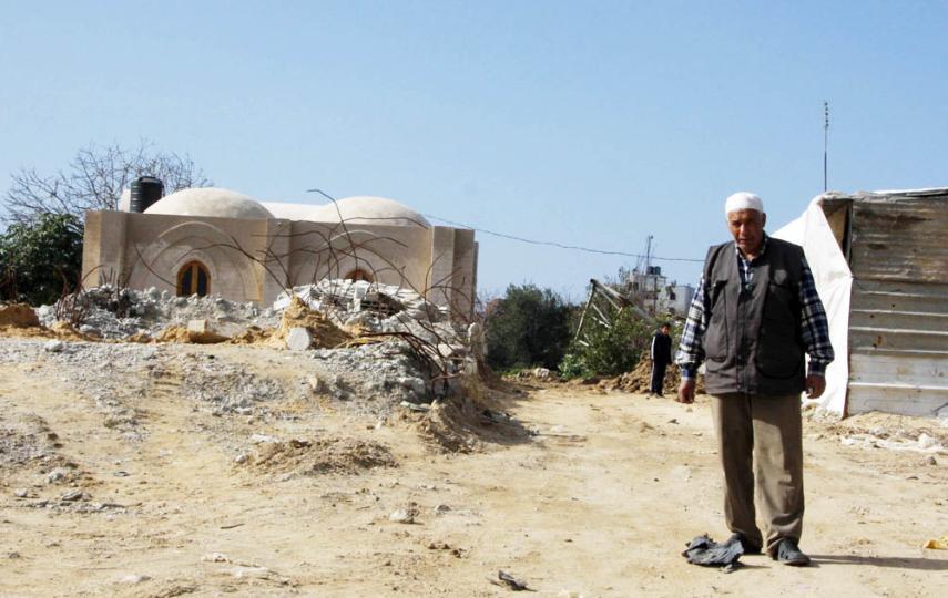 Hassan al-Err, 66, stands outside his new mud-brick house in eastern Jabaliya, Gaza. His family had been living in a tent for the past year since their home was destroyed in Israel's war in Gaza