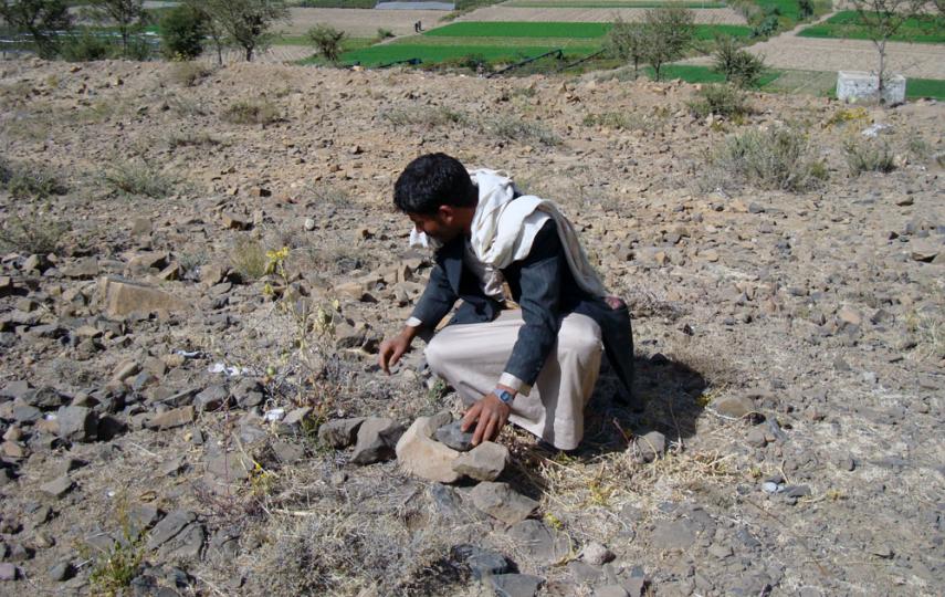 A Yemeni mine expert gathers rocks to mark an area suspected of having mines in Harf Sufyan District, Amran Governorate