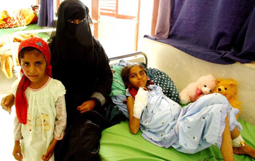 Mohra al-Sumeihi flanked by her daughters Hanaa and Adabah (lying on the bed), who were the victims of a landmine explosion outside an IDP camp in northern Yemen. Their father has sold everything he owns to pay for their hospital bill so far and more oper