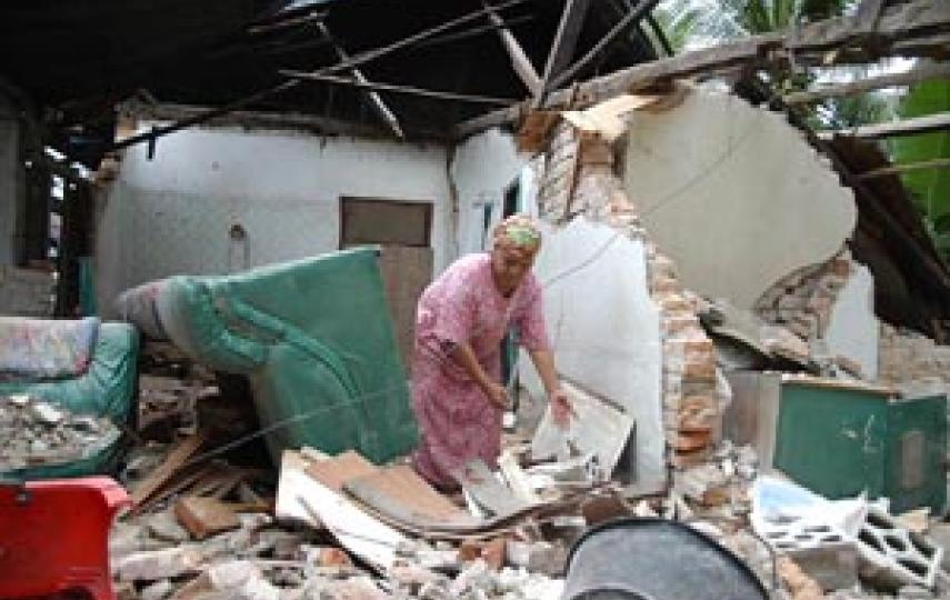 A woman looks for belongings in her home following the September 2009 Padang earthquake, West Sumatra