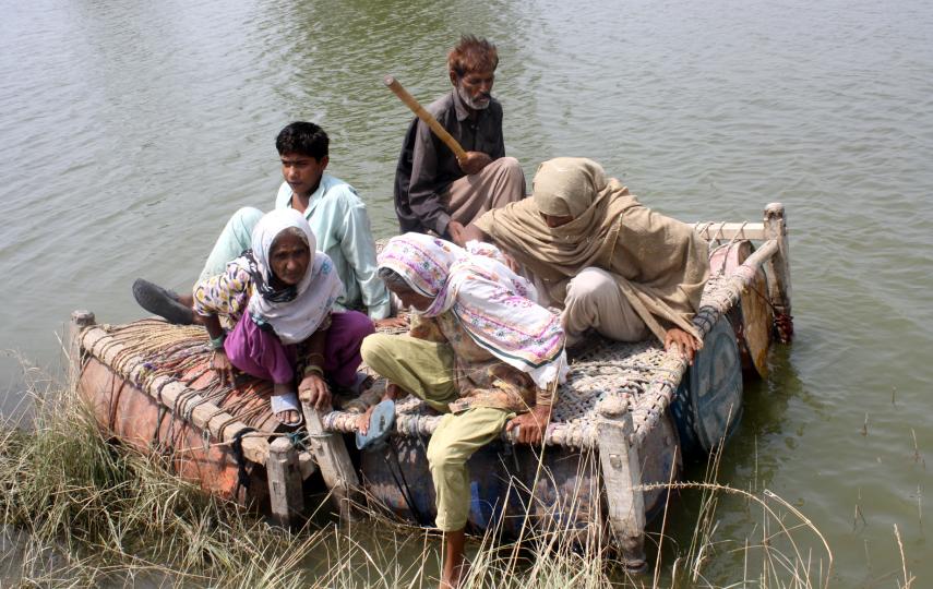 Residents use a makeshift boat to cross a flooded field in Punjab, Pakistan 