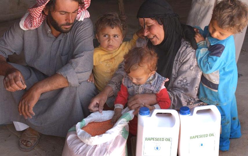 A Syrian family receives food aid at a WFP distribution point (file photo)