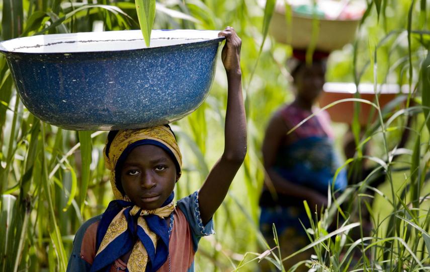 A young girl carries water from a river known to be infested with flies that cause river blindness. Ungwaku 1, Kajura District, in Kaduna State Nigeria