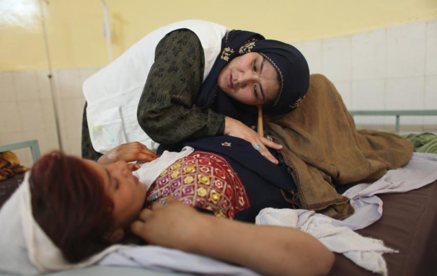 A midwife listens to the fetal heartbeat in the belly of an expectant mother at Boost hospital, Helmand Province