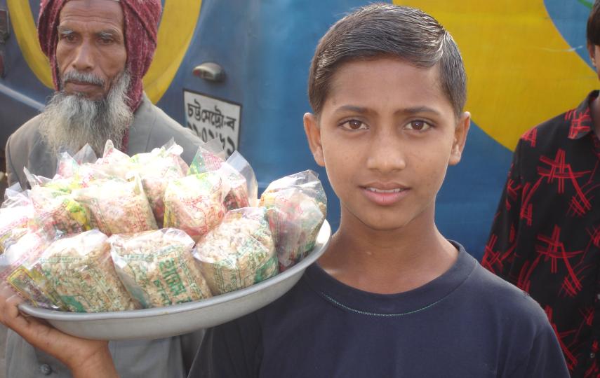 A young boy sells sweets on the streets of Dhaka. Thousands of people migrate to the city each year in search of better lives