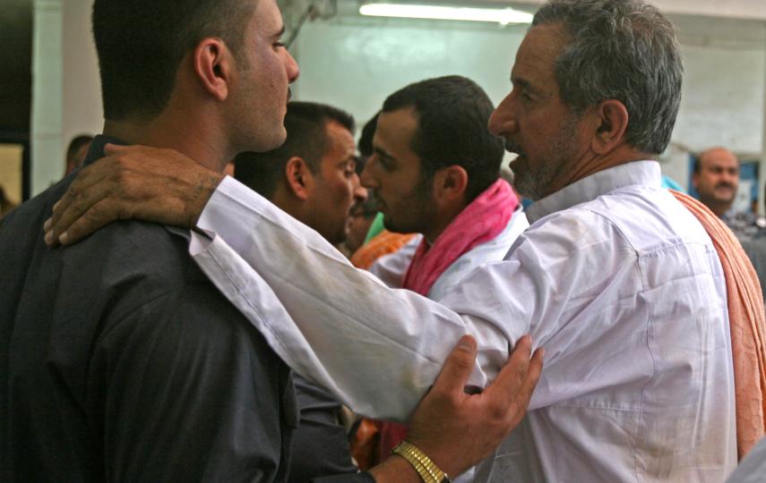 An Iraqi man speaks with an Iraqi Police Officer at the Iraqi Police Station in Karma, before he is released back to his family