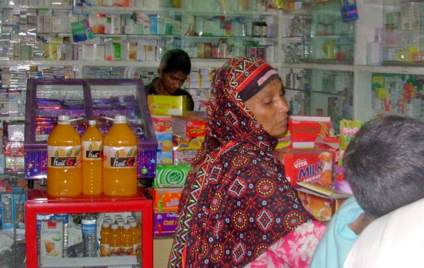 A woman buys drugs at a local pharmacy in Lahore, Pakistan. Many turn to pharmacies to meet drug needs
