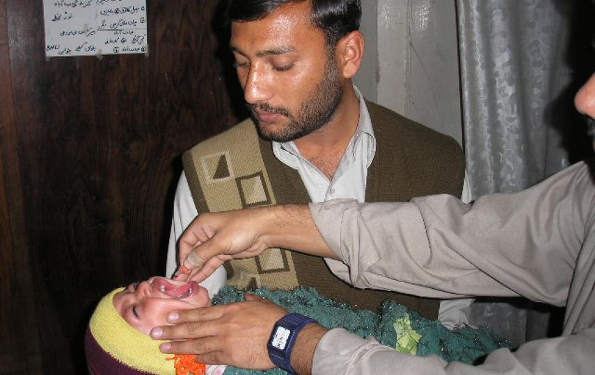 A child receives polio drops as a desperate struggle continues to contain the virus