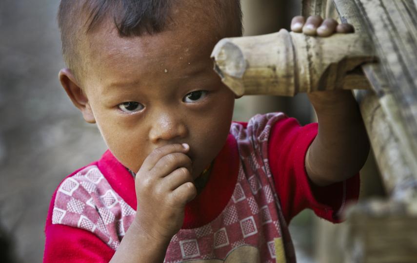 A young ethnic Karen refugee looks up from a newly erected bamboo hut in a displaced persons camp just inside Myanmar along the Myanmar-Thai border. The Karen, who have been involved in a civil war against Burmese government since 1946, continue to resist
