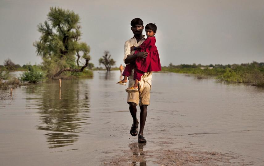 A man carries a child through the flood waters in Digri, Sindh province. Southern Pakistan has been struck by severe monsoon floods 12 months after last year's devastating flood emergency that affected most of the country