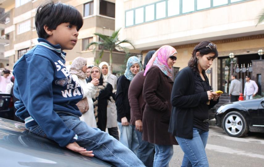 A young Egyptian boy waits while his mother stands in line to vote during the first free and fair parliamentary elections in Egypt in November 2011
