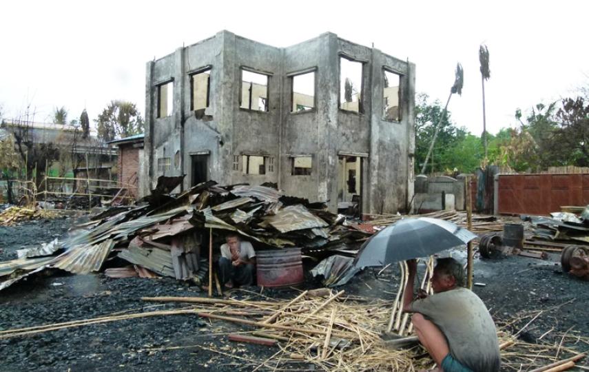 Two men sit under the the remnants of their homes in Sittwe, the provincial capital of Myanmar's western Rakhine State. More than 2,000 homes were destroyed in June following communal violence in the area
