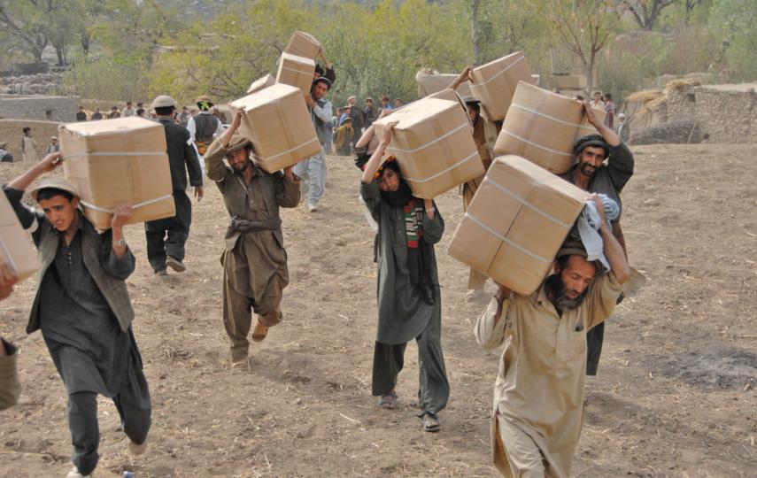 Afghan men from the Wagel valley carry boxes full of humanitarian aid during a handout in the Dudarek village in Afghanistan. The aid included blankets, pots and pans, and women's clothing