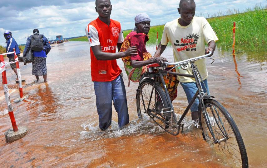 Soroti residents help an old woman to cross the flooded Awoja bridge in Teso sub region, Uganda (Sep 2012)