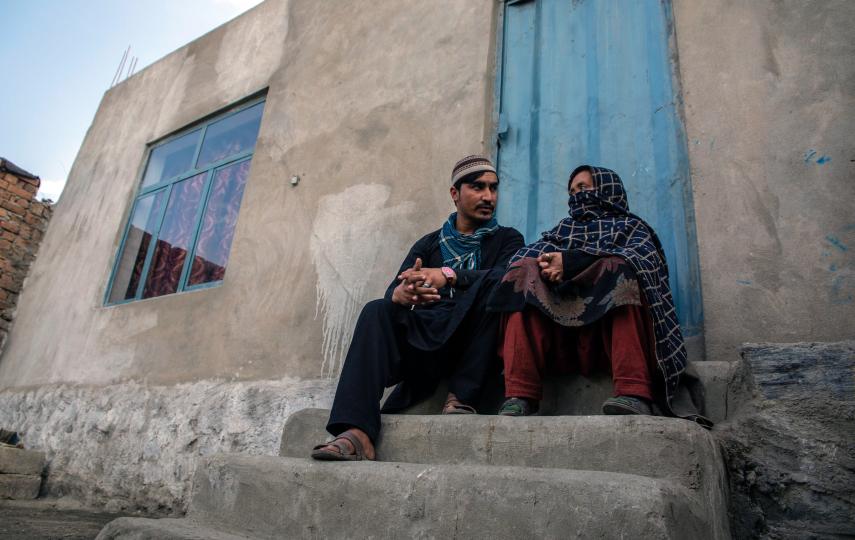 Photo of people who have returned to Afghanistan near Jalalabad sitting outside of their home.