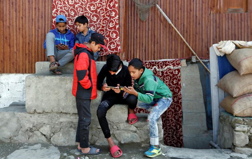 Children play games on their mobile phones in Srinagar in October 2019.