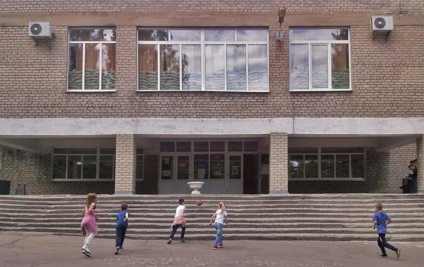 Children play outside of a school in May 2018 in Mariinka, near the line of contact that separated territory in eastern Ukraine held de facto by Russia from that under Ukrainian control.