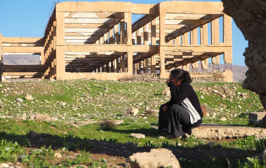 Photo of a Yazidi woman in Sinjar grieving by a mass grave