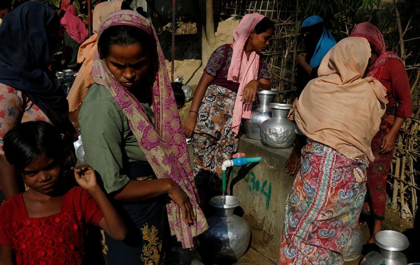 Rohingya refugees fill containers with water at the Onchiprang refugee camp near Cox’s Bazar, Bangladesh, in December 2017. Up to 20 people can share a single outdoor latrine in the camps.