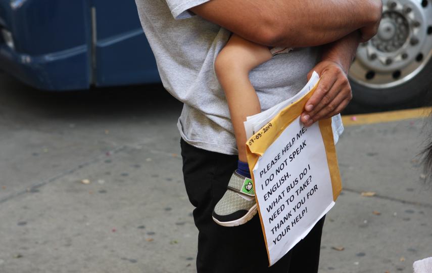 Photo of immigrant from Mexico into the US holding a sign.