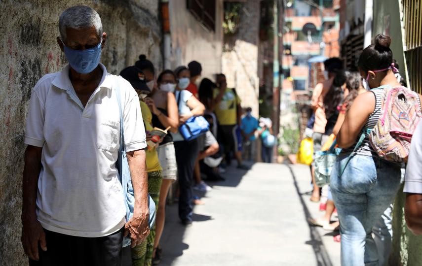 People wait in line to receive food in Caracas, Venezuela