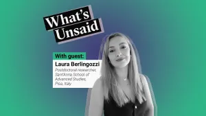 What's Unsaid podcast teaser picture with a portrait photo in black and white of Laura Berlingozzi, postdoctoral researcher, Sant'Anna School of Advanced Studies, Pisa, Italy over a radial gradient background. The colour at the centre is a purplish blue and the colour outside is green. On the top right, a bit skewed to the right we see the title of the podcast: What’s Unsaid. 