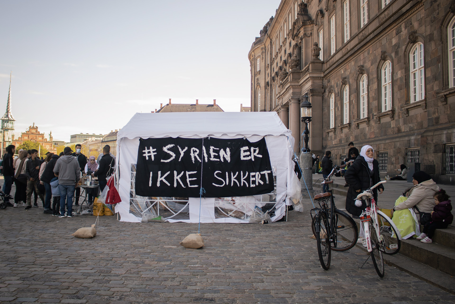 “Syria is not safe”, reads the sign (in Danish) on a tent outside the parliament in Copenhagen as protesters launch a May 2021 sit-in against the Danish government’s decision to revoke Syrian refugees’ residency permits.