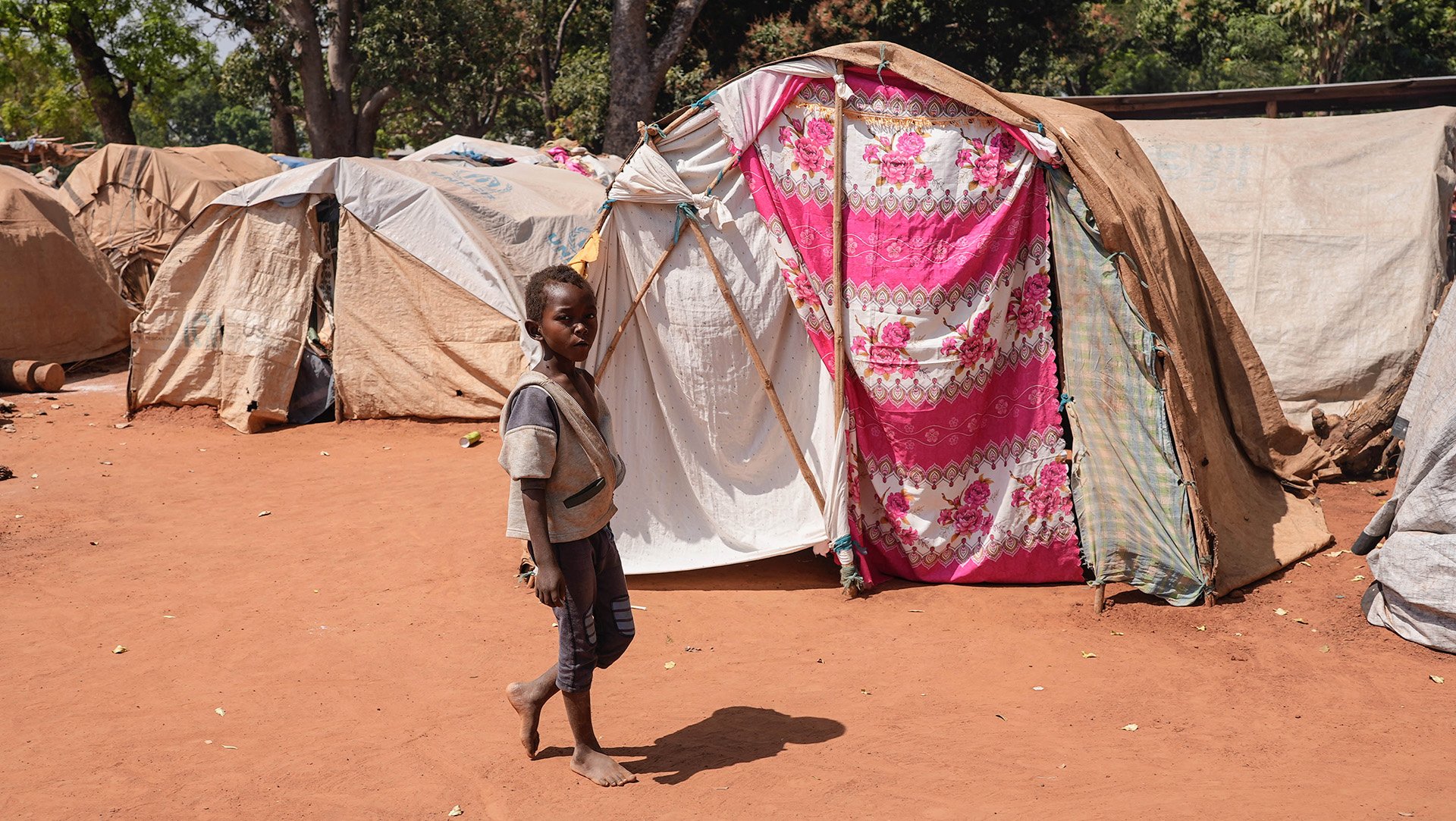 A child walks through a makeshift displacement camp outside a church in Tambura town. Fighting in the area has displaced at least 80,000 people in recent months. 