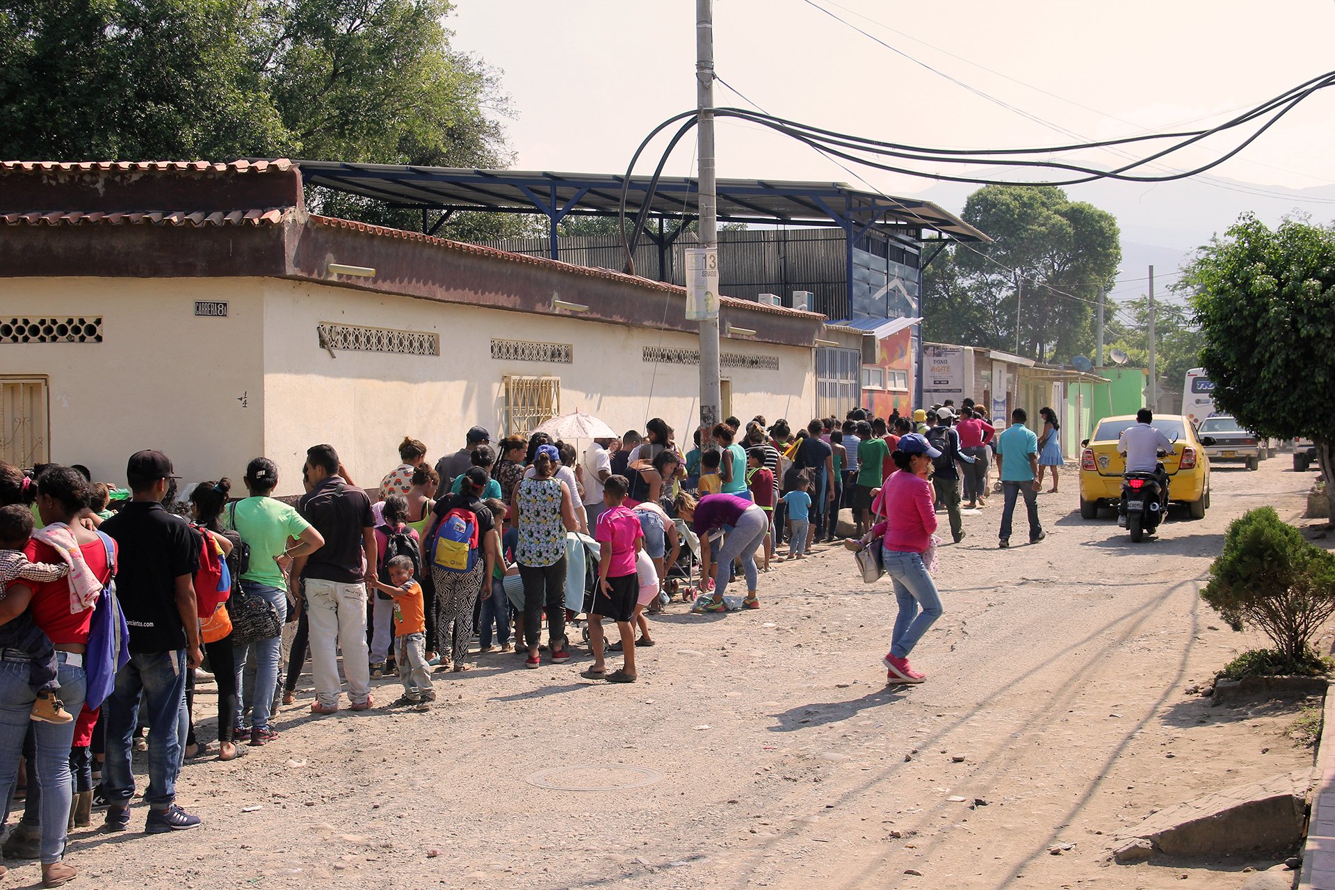 A long line of people outside of a soup kitchen