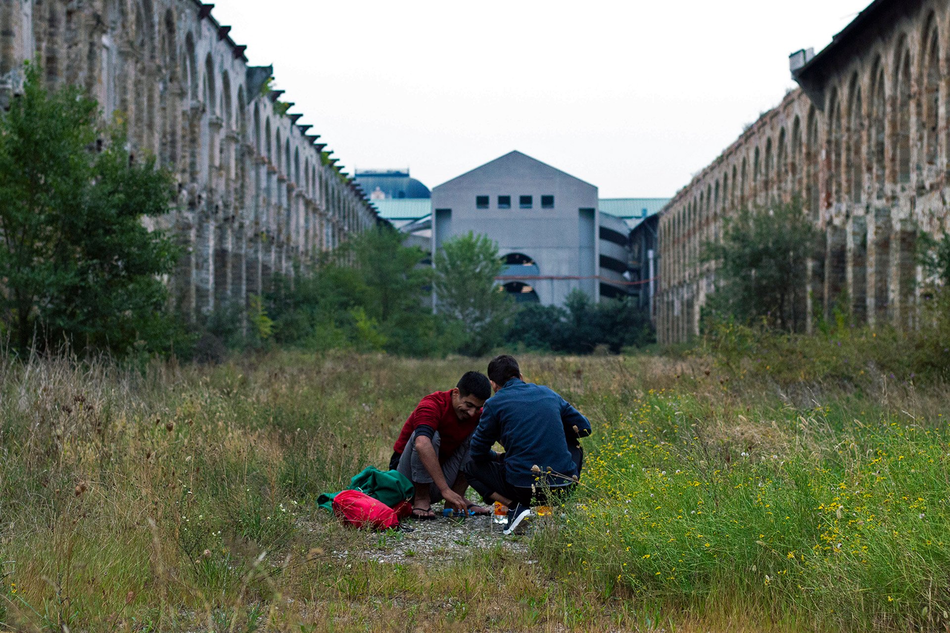 Two Afghan asylum seekers outside the abandoned building near the Trieste train station