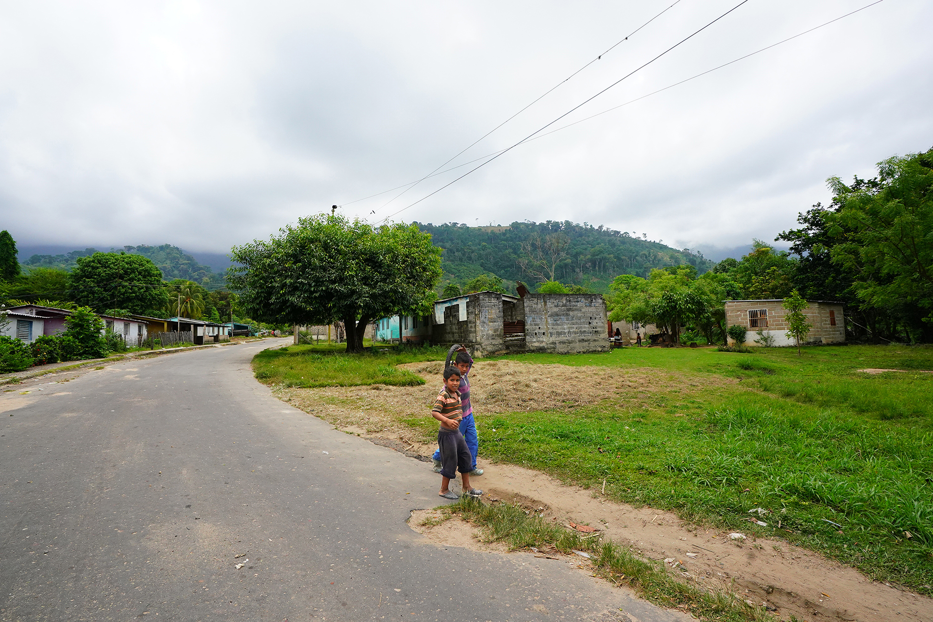 Two children walk in a village