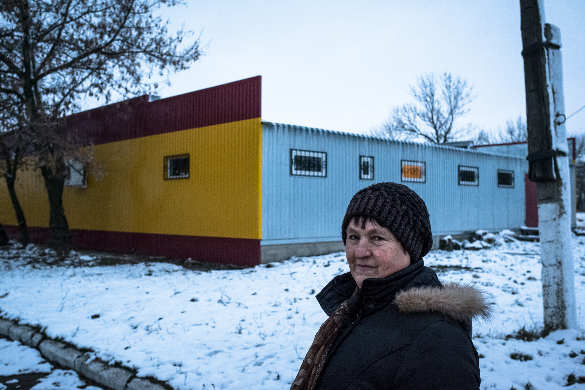 Photo of a woman in Ukraine outside in the snow in front of a building