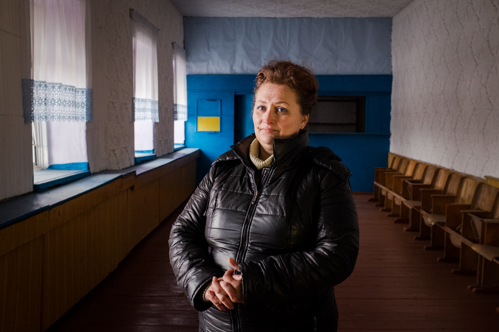 Photo of a woman in Ukraine inside a large hallway painted blue and yellow