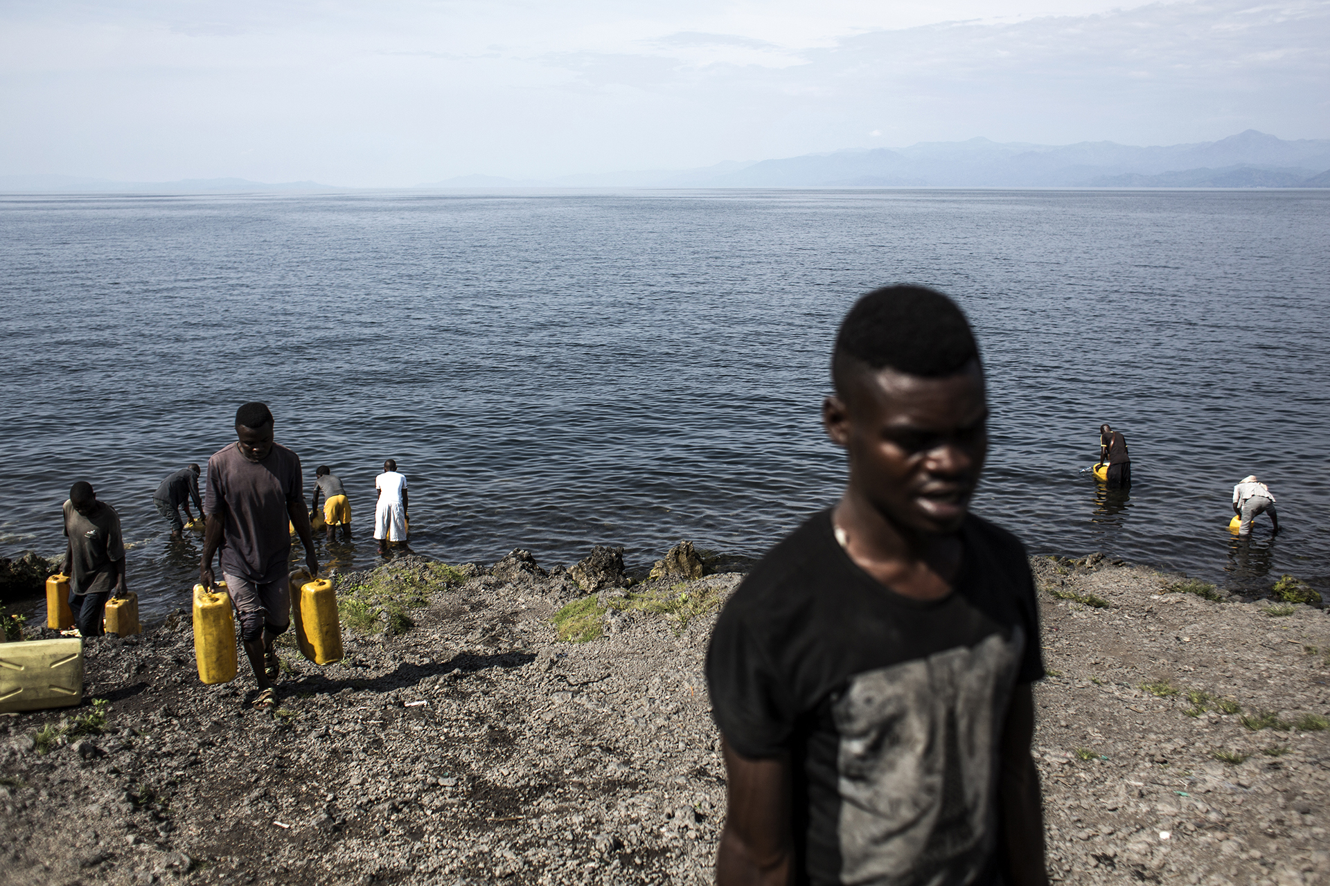 Men are seen collecting water from Lake Kivu.