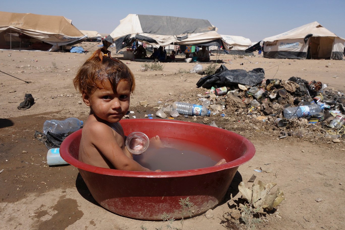 IDP child in tub of dirty water