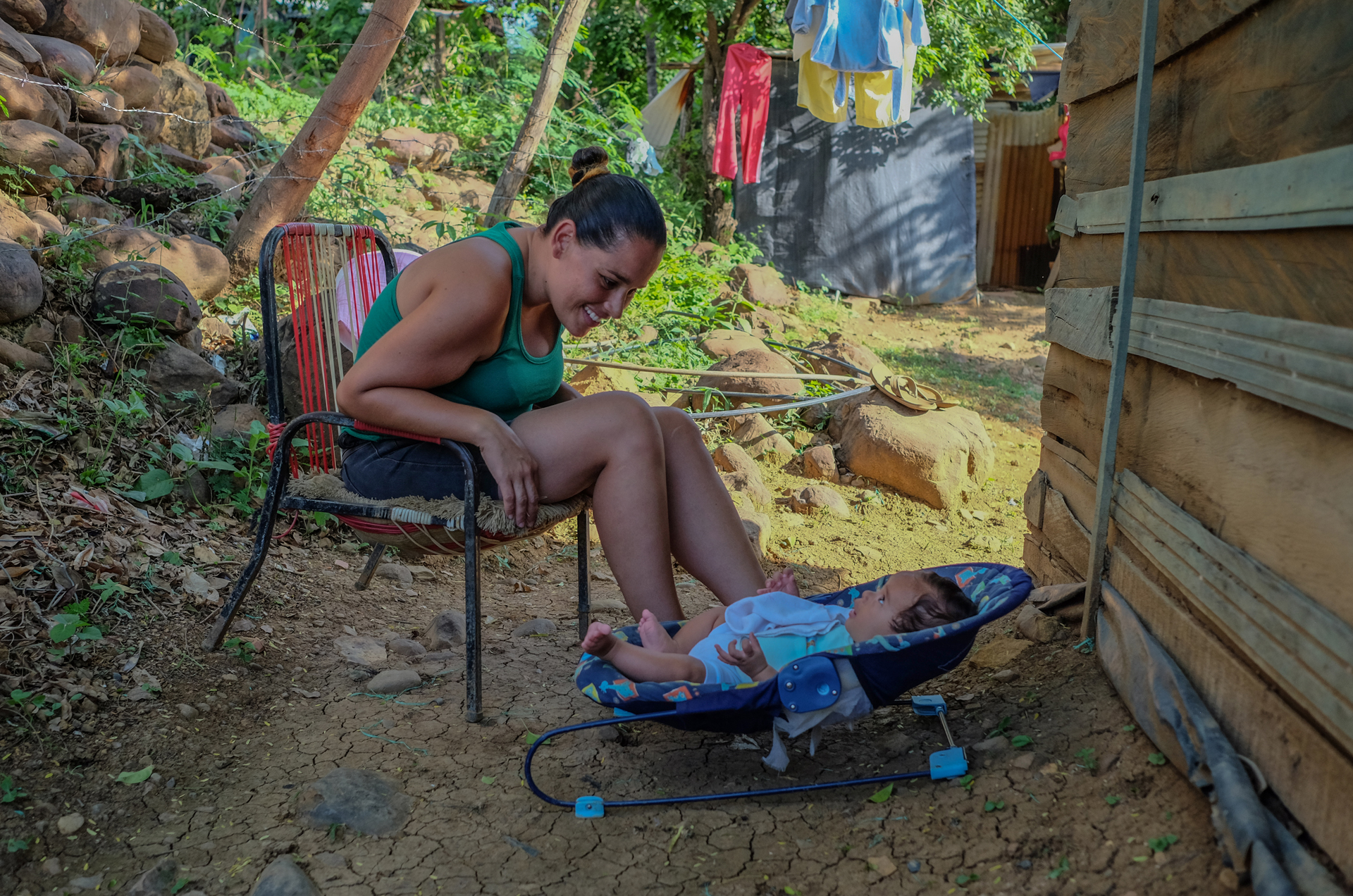 Élida Betancourt and her son Christopher sitting outside the home, owned by a Colombian, where they have been living in Las Delicias for nine months. The don't pay rent, only service bills.