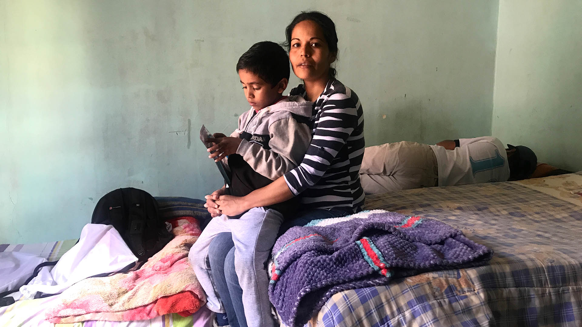 Adriana Aldana's son sits on her knee.