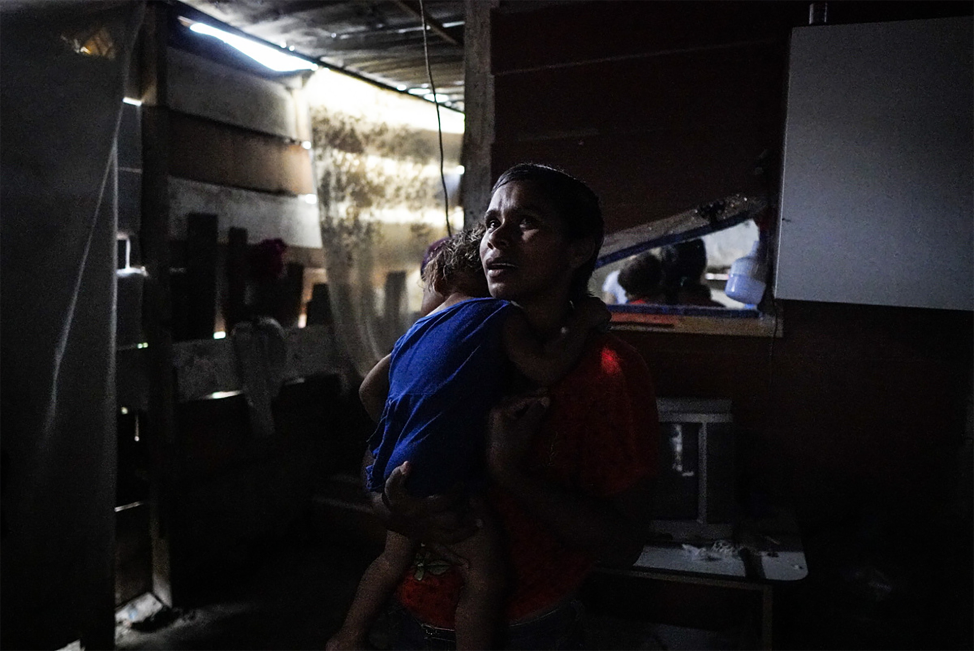 Alvarez holding her one year old daughter in her house in Petare, Caracas.