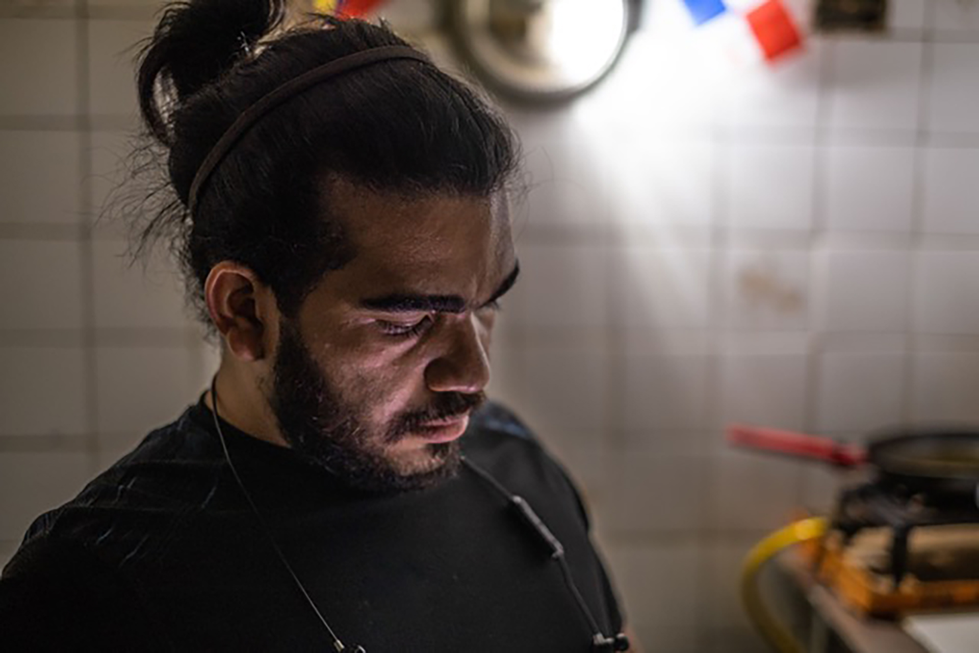 Venezuelan immigrant Nelson Diaz cooks in his new home in Panama City