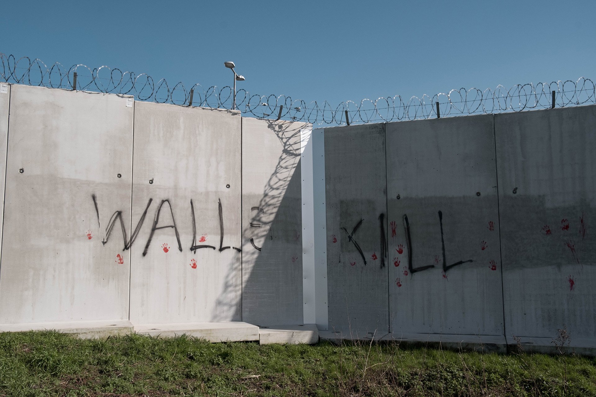 An anti-migrant wall surrounding a petrol station in Calais.