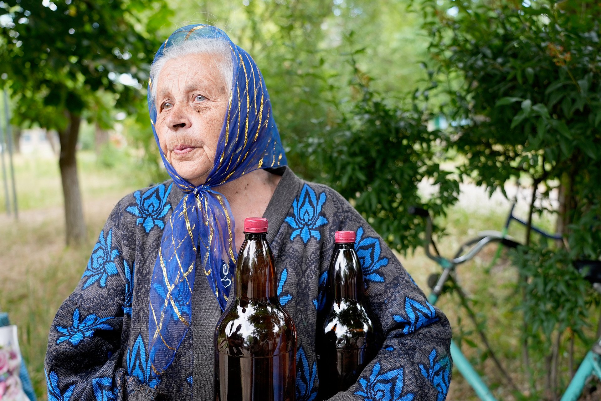 A woman holds two bottles of water given to her during an aid distribution in a frontline town in the eastern region of Donbas.